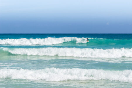 A surfer at Playa Macao in Dominican Republic near Punta Cana.