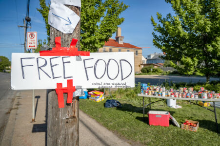 Sign that reads "FREE FOOD Central area neighborhood development organization". 

Food stands popped up after grocery stores were burned and other store damage following nights of riots in Minneapolis after the death of George Floyd.