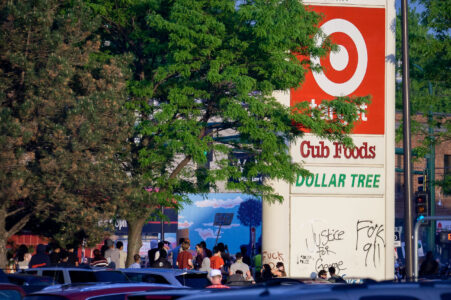 Protesters gather below a Target sign across from the Minneapolis Police third precinct.
