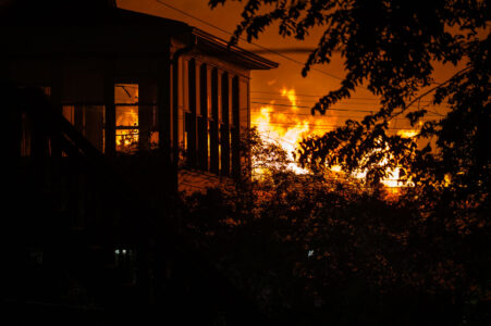 A fire burning across the street from a home on E 29th St on the 2nd day of protests in Minneapolis following the death of George Floyd.