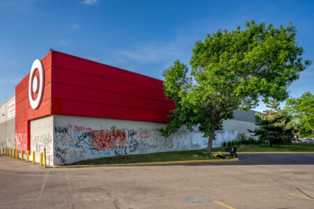 A man lies on the grass outside of the Target Store on East Lake Street in South Minneapolis. Graffiti covered the store that sits across from the Minneapolis Police 3rd Precinct.