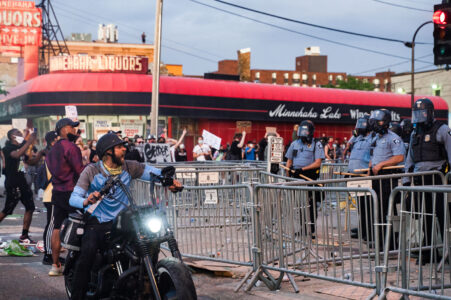 A man on a motorcycle yells at Minneapolis Police who are outside the 3rd Precinct as protesters continue to gather on the 2nd day of protests in Minneapolis following the death of George Floyd.