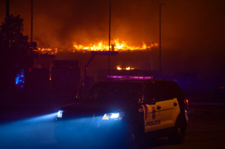A Minneapolis Police squad car while buildings burn behind it during the 2nd day of protests in Minneapolis following the death of George Floyd.