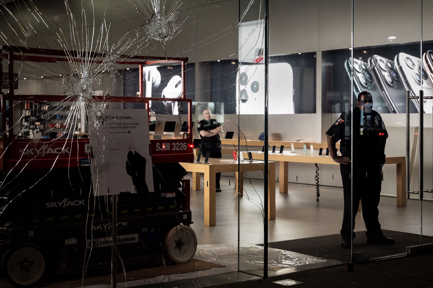 Private security patrols Apple store behind broken window