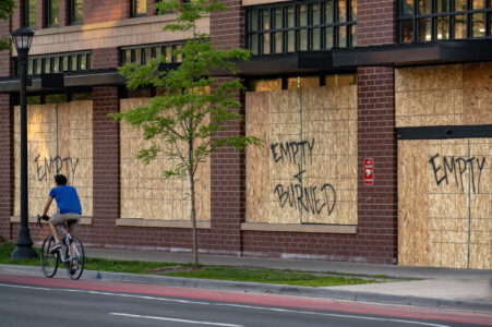A cyclist bikes down Hennepin Avenue in Uptown Minneapolis past a boarded up Walgreens Pharmacy. 

Boards were placed after unrest in Minneapolis over the killing of George Floyd on May 25th, 2020.
