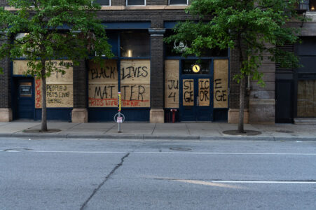 "Peoples Pets Live Here", "Kids Live Here", "Black Lives Matter" and "Justice 4 George" written on boards in downtown Minneapolis on 06/04/20.