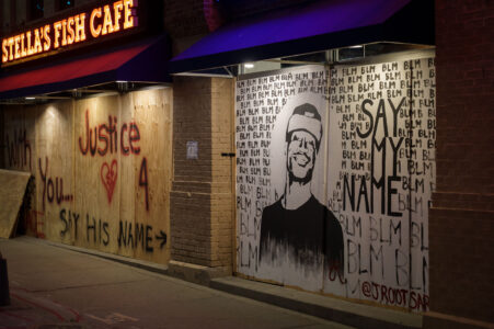 Boards reading "Say His Name" "Justice" and a drawing of George Floyd on Stella's Fish Cafe windows on Lake Street in Uptown Minneapolis. June 2020