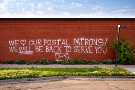 Graffiti reading “We love our postal patrons! We will be back to serve you”. The post office was destroyed in the days following George Floyd May 2020 murder.