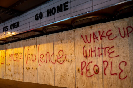 Boarded up Uptown Theater in Uptown Minneapolis with boards reading “Silence = Violence” and “Wake Up White People”.