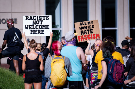 Protesters hold up signs outside the Federal Courthouse in downtown Minneapolis. “All My Homes Hate Facism”. The protest and rally was regarding Federal officers being deployed to other cities during protests.