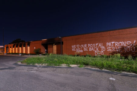 Graffiti on the damaged Lake Street Station post office. 

“We love our postal patrons! We WILL be back to serve you!”