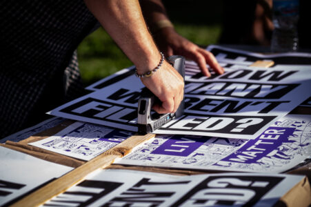Protest signs being stapled together prior to the “How many weren’t filmed?” March through Uptown Minneapolis.