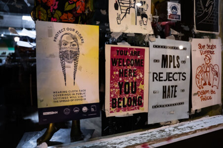 Signs in a window of a store in Minneapolis that read “Protect our elders” “MPLS Rejects Hate” “You are welcome here you belong”