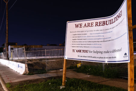 A sign constructed on Minnehaha Ave by Wellington Management stating their intent to rebuild. This block suffered substantial arson damage during unrest.