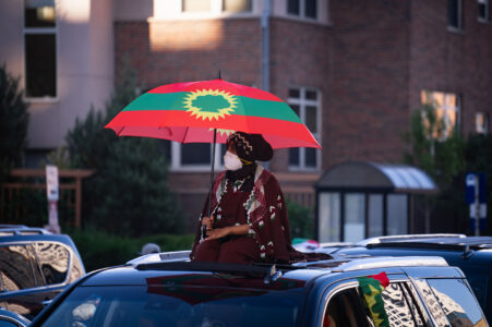 Woman with an Oromo flag during a march through Northeast Minneapolis.