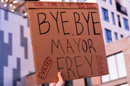 Protester outside Minneapolis Mayor Jacob Frey’s home holds up a sign that reads “Your time is up! Bye, Bye Mayor Frey. Evicted”. Protesters demanding the mayor do something about homelessness in the city.