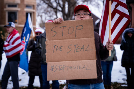 A protester holds up a sign that reads “Stop The Steal” outside the Minnesota Governor’s mansion in St. Paul, Minnesota on November 14, 2020.