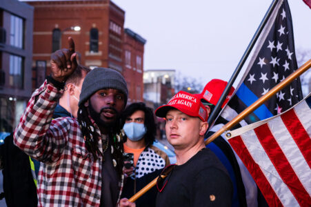 Two men wearing "Make America Great Again" hats disrupt a housing protest outside Minneapolis Mayor Jacob Frey’s home.