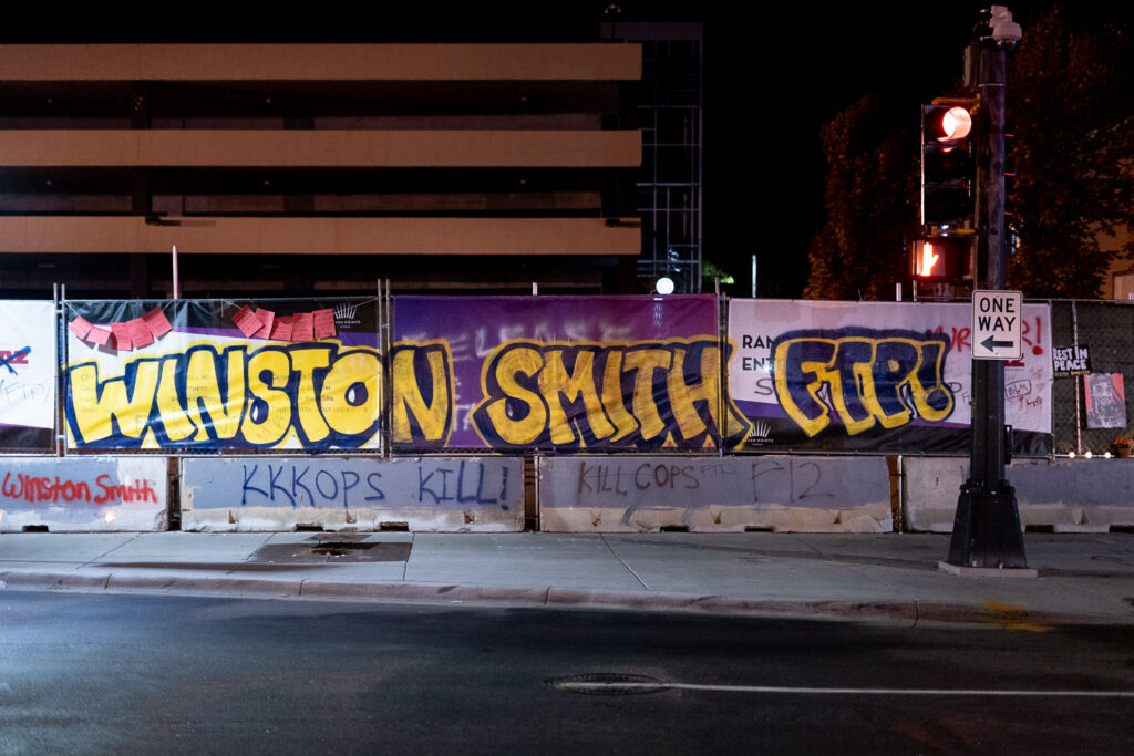 Graffiti lines the banners at Lake & Girard where Winston Smith was killed 5 months ago.