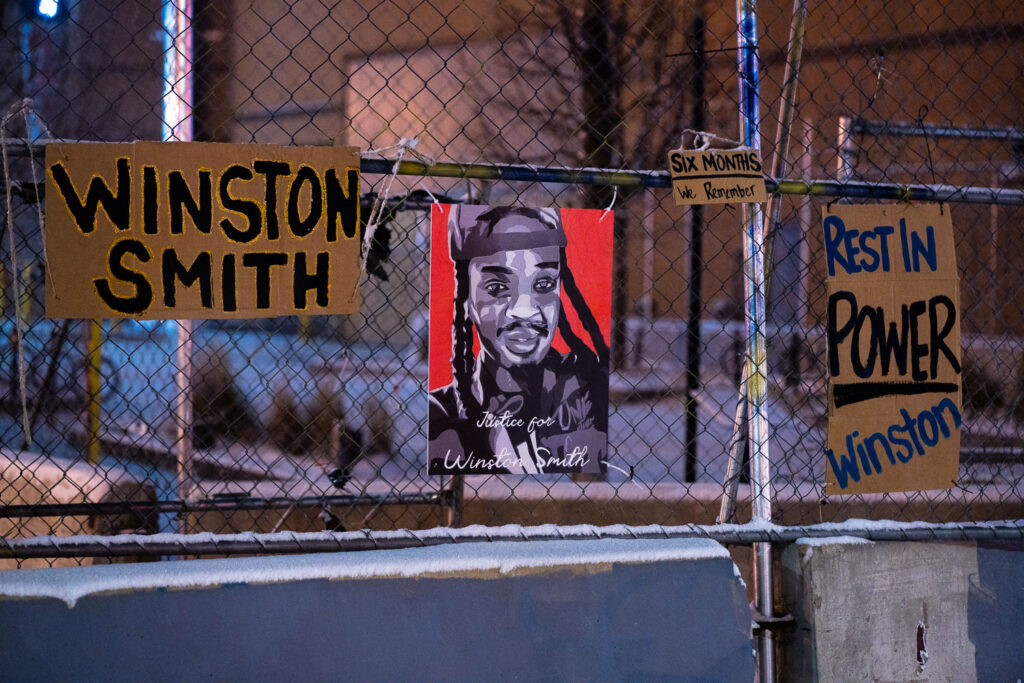 Protest signs hang on fencing outside the Lake & Girard parking ramp. The day prior was 6 months from the day WInston Smith was killed.