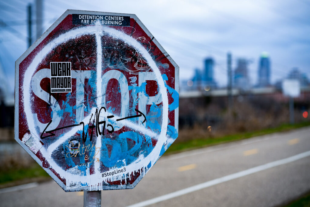 A stop sign covered in paint and stickers in Minneapolis.