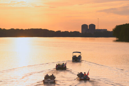 Boaters on the Mississippi River driving towards the Prairie Island Nuclear Generating Plant. Treasure Island Resort & Casino, which is just past the plant, lit off it's annual 4th of July fireworks at dusk.