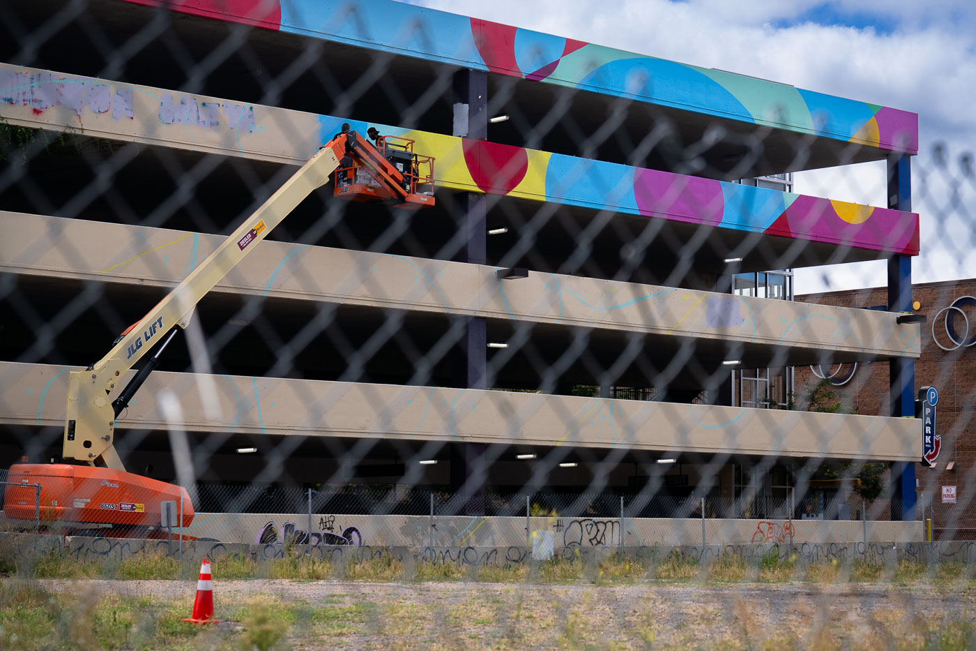 Lift being used to paint billboard on parking ramp