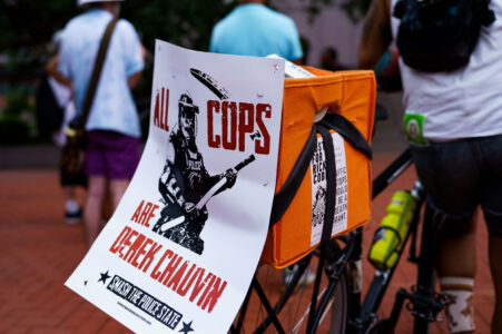 A protester at a rally outside the Hennepin County Courthouse with a sign that reads “All Crops Are Derek Chauvin”. Those at the rally are asking for Hennepin Attorney Mary Moriarty to charge the Minnesota State Trooper Ryan Londregan in the killing of Ricky Cobb II. Cobb was killed on July 31 after being shot during a traffic stop.