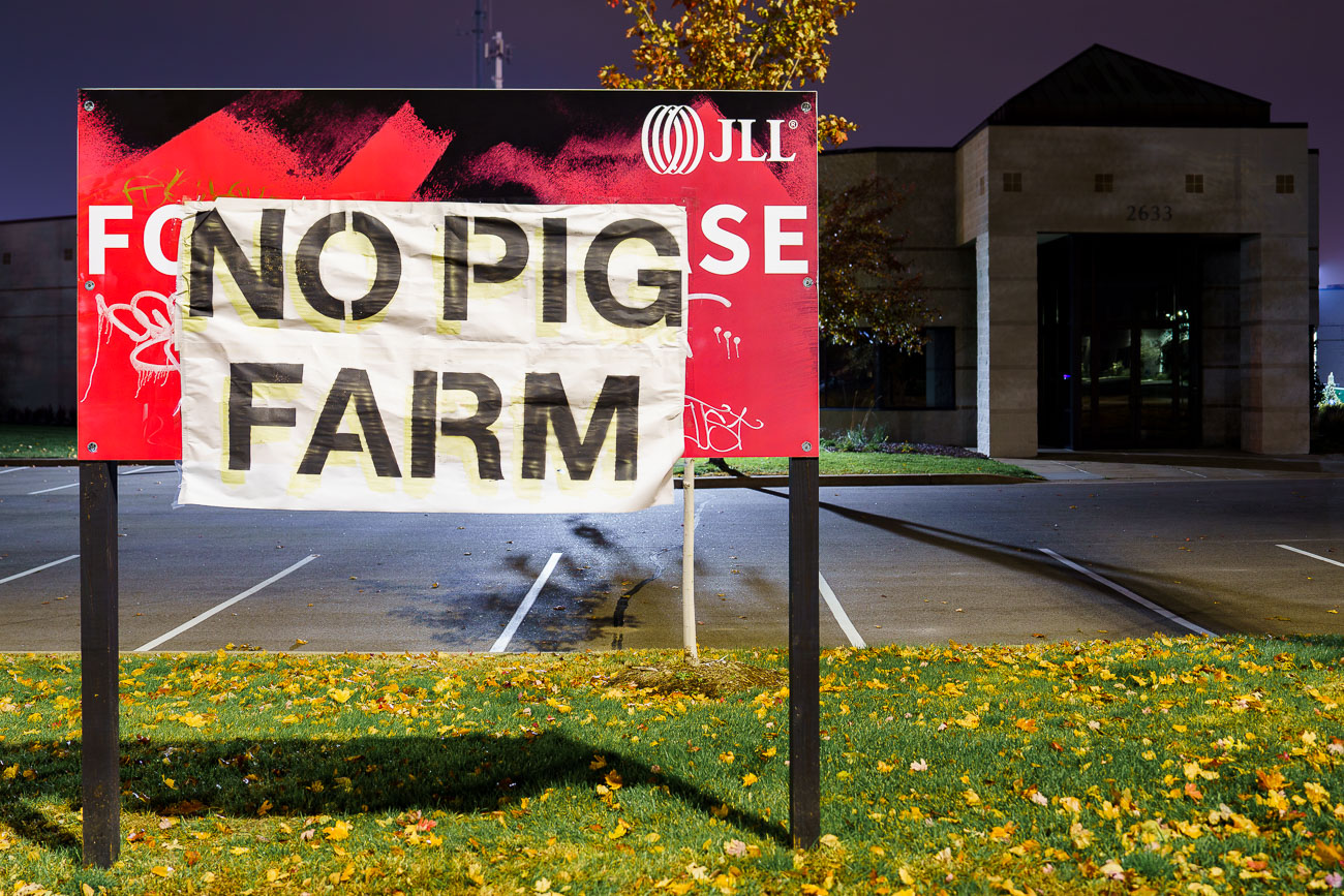 Protest sign at site of new police station, no pig farm