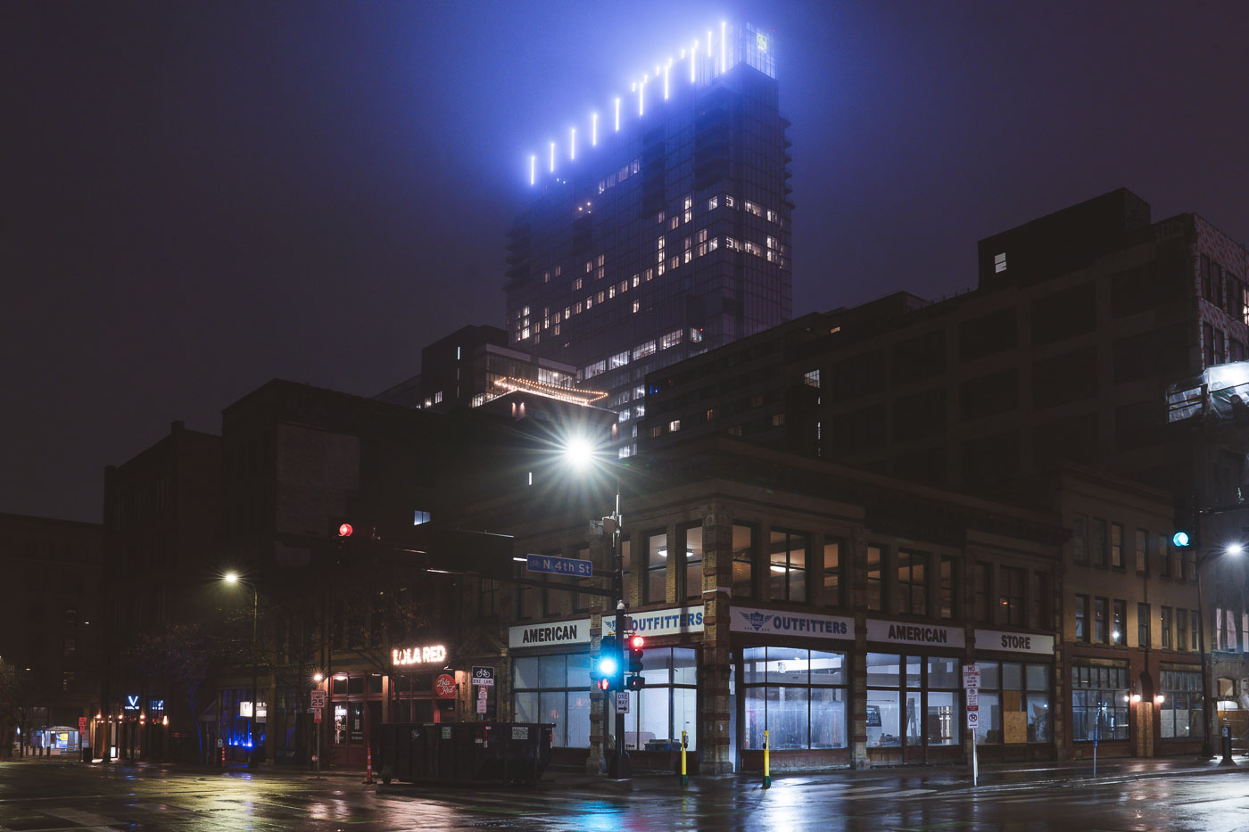 Intersection on rainy night with building in fog