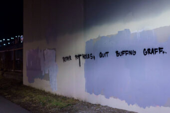 Graffiti on the Midtown Greenway in South Minneapolis that reads "Repair Pot Holes, Quit Buffing Graffiti".