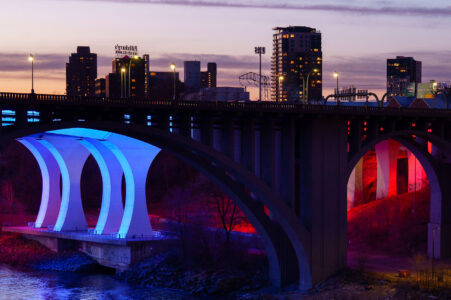 The 10th Avenue and I-35W bridges lit up at sunset near downtown Minneapolis. March 2024.