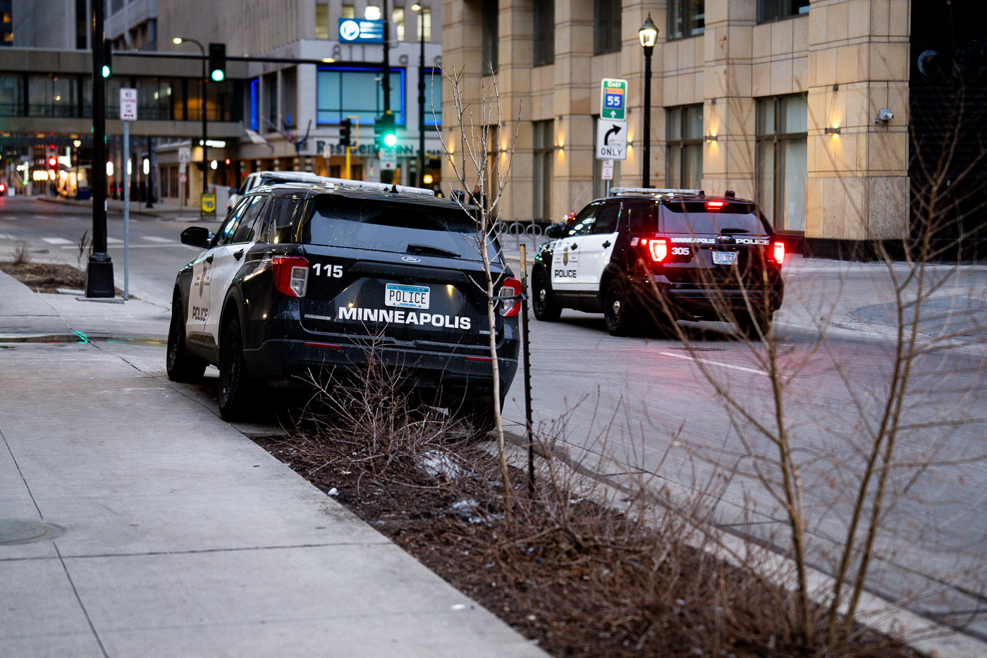 Squad car parked on sidewalk as another drives by