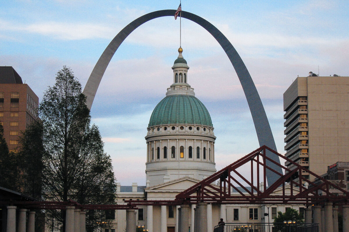 The Gateway Arch, a stainless steel curve, stands behind the Old St. Louis County Courthouse in St. Louis, Missouri. The Arch commemorates westward expansion, and the Courthouse was the site of the Dred Scott case.