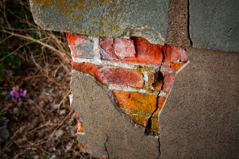 Spalling Masonry on Abandoned Minnesota Church 1 Spalling masonry exposes red brick on an abandoned church wall in Minnesota.