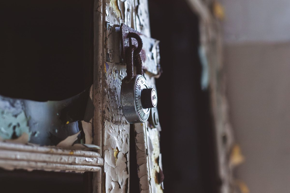 Padlock on deteriorating wooden door frame at Kings Park Psychiatric Center, New York.