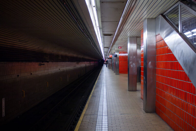 Lexington Avenue–63rd Street Subway Station – New York City 1 The Lexington Avenue–63rd Street station in Manhattan, part of the IND and BMT lines of the New York City Subway, is shown here in its distinctive red-tiled design. Opened in 1989 as part of the 63rd Street Tunnel project, the station serves the F and Q trains, linking the Upper East Side to Queens and the Second Avenue Subway. Its sharply linear geometry and long central platform exemplify late-20th-century transit architecture, emphasizing function and durability. The bright red glazed brick walls contrast with the metallic fixtures and fluorescent ceiling strips, creating a visual rhythm typical of New York’s underground infrastructure during the city’s major transit expansion era.