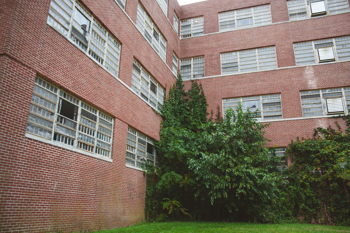 Red brick institutional building with barred windows and ivy-covered courtyard at Kings Park Psychiatric Center.