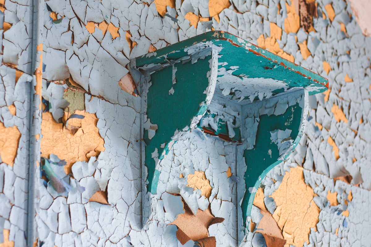 Peeling paint on wall and deteriorating green mailbox at abandoned Kings Park Psychiatric Center, New York.