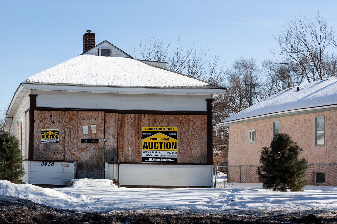 Boarded up home with Lender Foreclosure sign