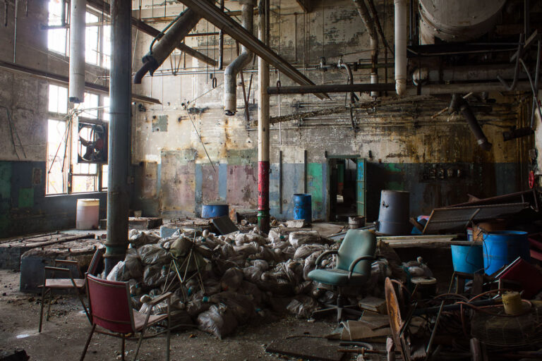 Abandoned Dixie Brewery Interior, New Orleans 1 Interior of the abandoned Dixie Brewery in New Orleans, filled with debris, trash bags, and industrial piping. The brewery ceased operations in 2005 after Hurricane Katrina.
