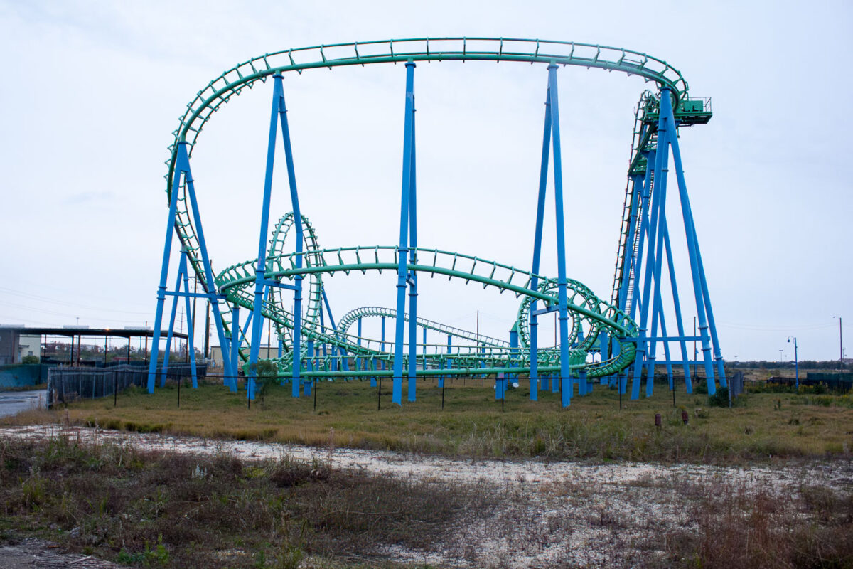 Abandoned green roller coaster with blue supports at Six Flags New Orleans, closed since Hurricane Katrina in 2005.