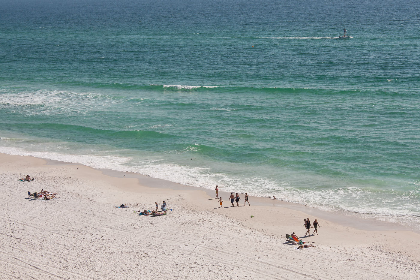 Beach goers walking on the beach in Panama City Beach