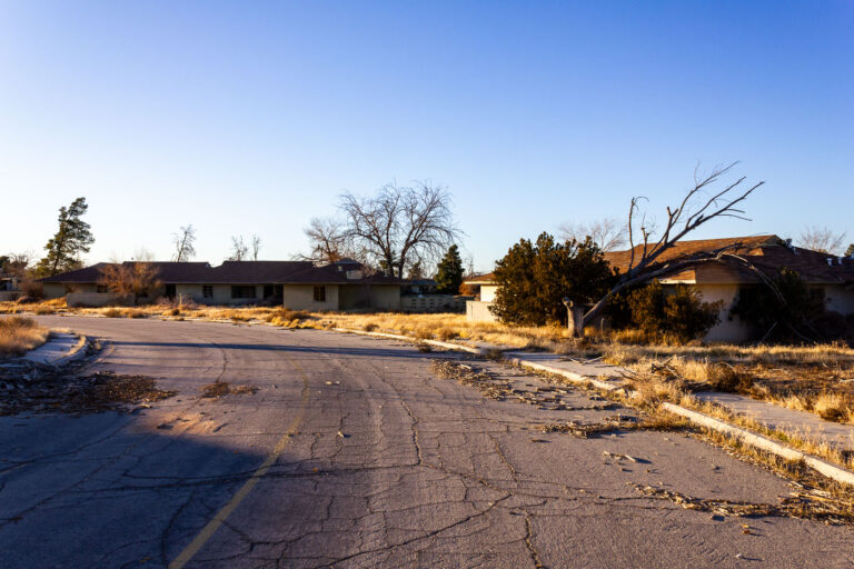 Abandoned Housing Blocks, Former George AFB, Victorville, CA 1 Abandoned housing blocks at the former George Air Force Base in Victorville, California, stand in disrepair under a clear desert sky.