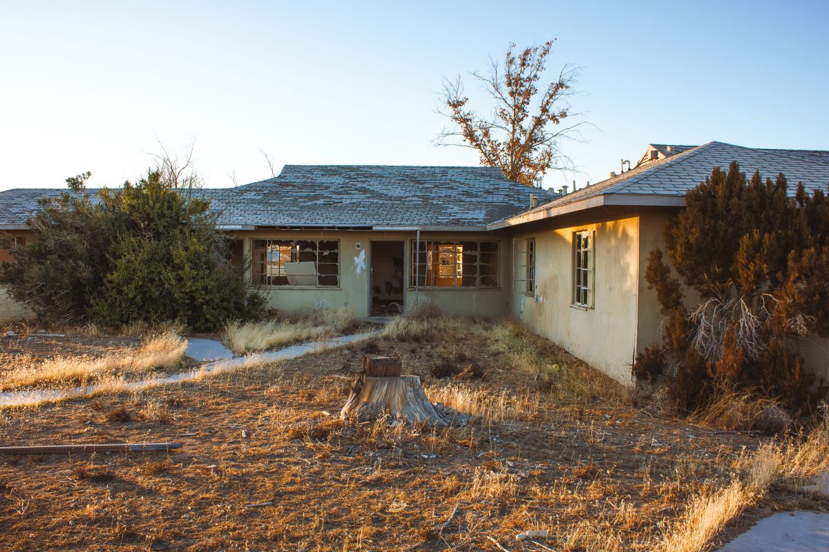 Abandoned single-story residential building with broken windows at George Air Force Base in Victorville, California.