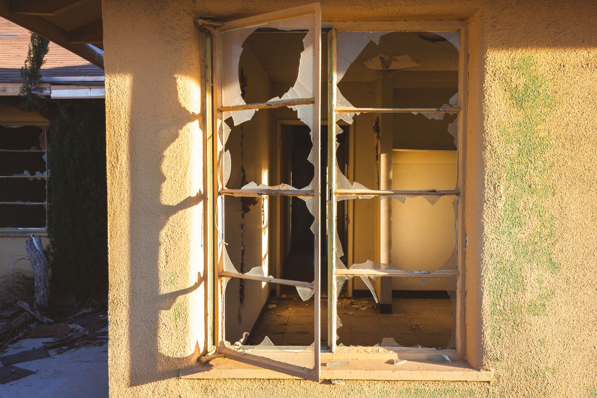 Broken glass doors of abandoned residential building at George Air Force Base in Victorville, California.