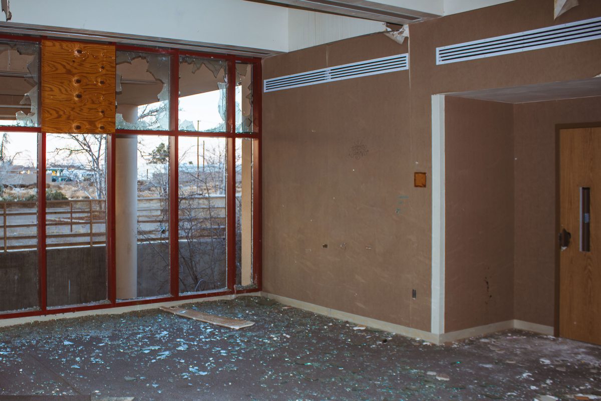 Abandoned residential building interior with broken windows and debris at George Air Force Base in Victorville, California.