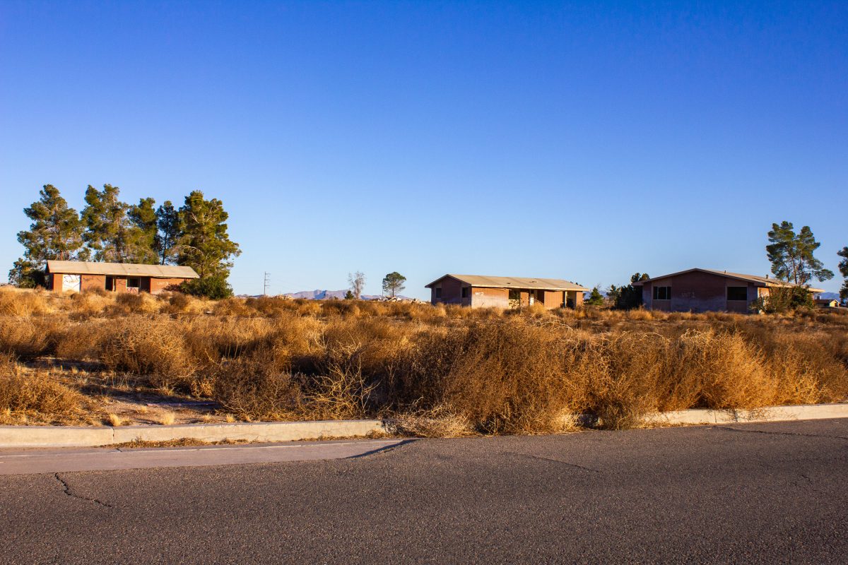 Abandoned residential buildings and dry vegetation at George Air Force Base in Victorville, California.