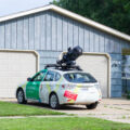 A Google Maps Street View car parked in a residential driveway.