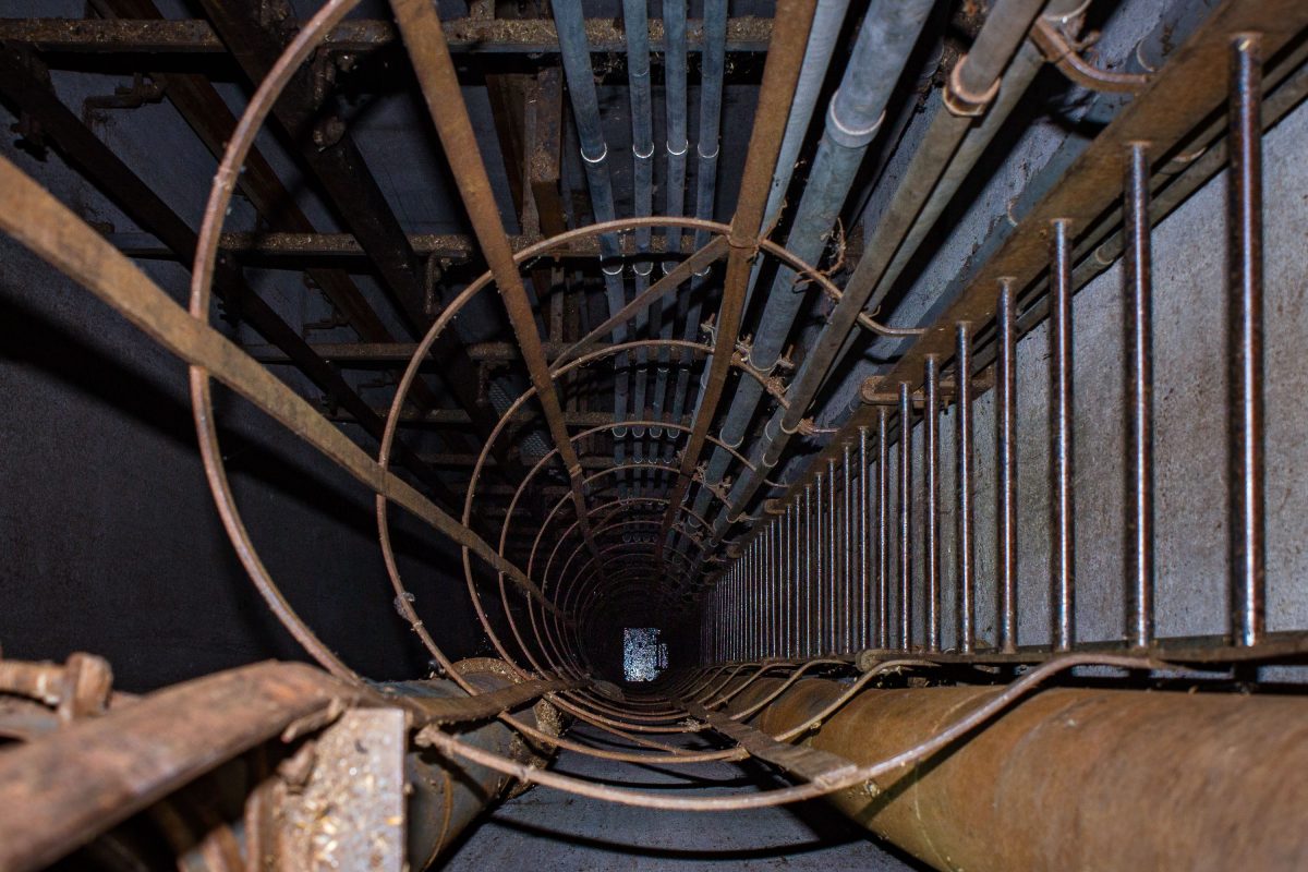 Interior of abandoned Fruen Mill grain elevator in Minneapolis showing rusted metal framework and industrial machinery.